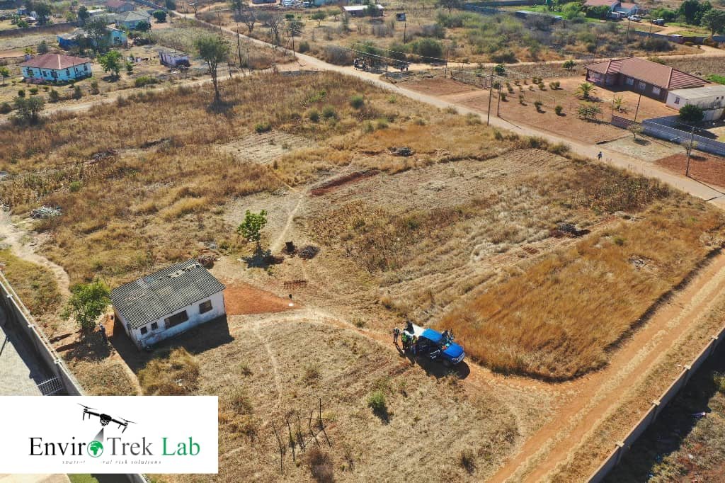 Aerial drone photograph of a development site with buildings, plots and the EnviroTrek Lab survey vehicle
